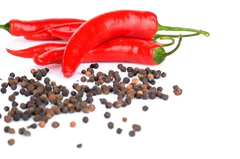 Perspective view of spicy chilli pepper and black peppers on a white backgrou Stock Photos