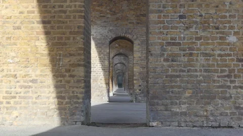 A perspective view through a series of repeating brick arches. Stock Footage 345266089