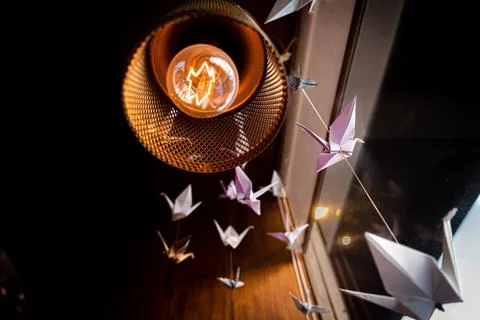 Perspective view from underneath of several origami swans hanging from the roof Stock Photos