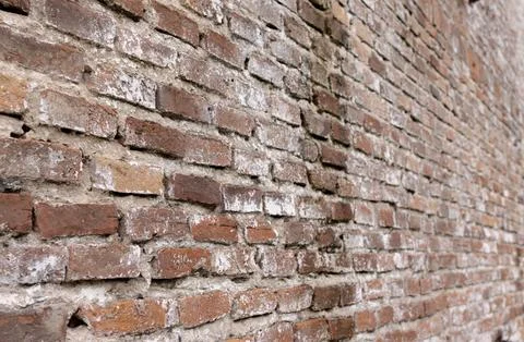 Perspective view of a wall with red aged bricks Old urban textured background Stock Photos