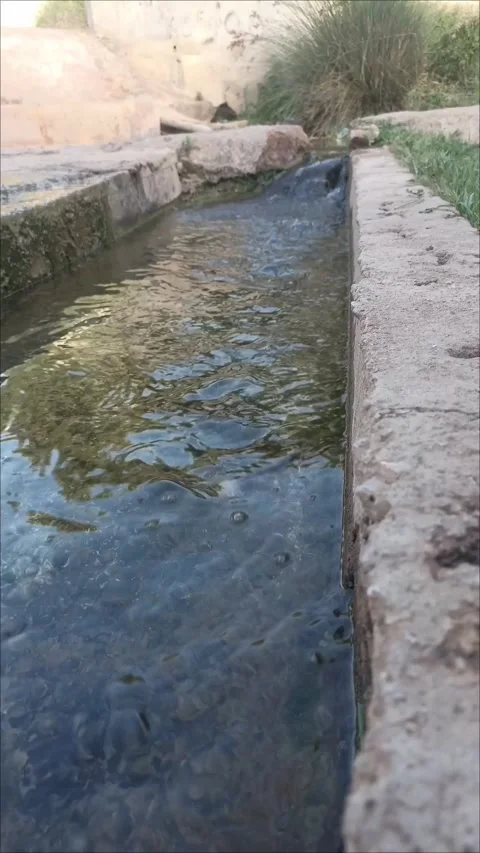 Perspective view of water flowing down a concrete ditch for irrigation Stockbeeldmateriaal 339737952