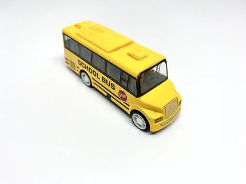 Perspective view of yellow school bus toy for kids isolated on white background Stock Photos