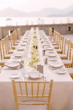Perspective Wedding dinner table reception view. A long rectangular table with a Foto stock