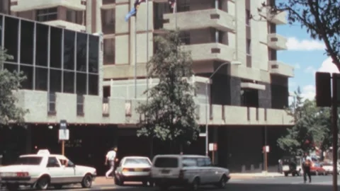 Perth - 1988: Facade Of Office Building With Flags - Cars Run Thorough The Road Stock Footage 167766583