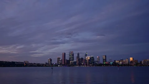 Perth city at dusk morphs into night, viewed over the Swan River Stock Footage 301031023