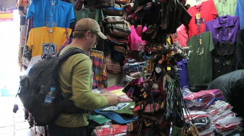 Peru Cusco man in cap shops at vendor booth Stock Footage 40000514