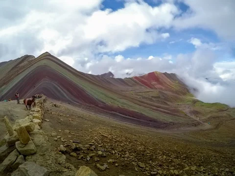 Peru Rainbow Mountain Timelapse Clouds Rolling up towards Summit Stock Footage 128210516