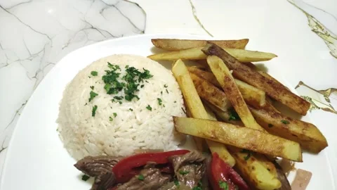 Peruvian beef with rice and potatoes called "Lomo saltado". Food in Peru Vidéo 285361436