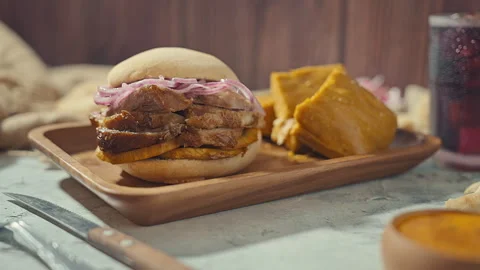 Peruvian breakfast, Chicha Morada alongside a Peruvian Pan con Chicharrón Combo Stock Footage 339078034