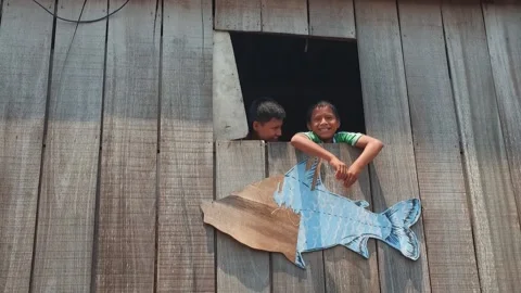 Peruvian children boys wave from the window of a wooden house. 스톡 동영상 233288659