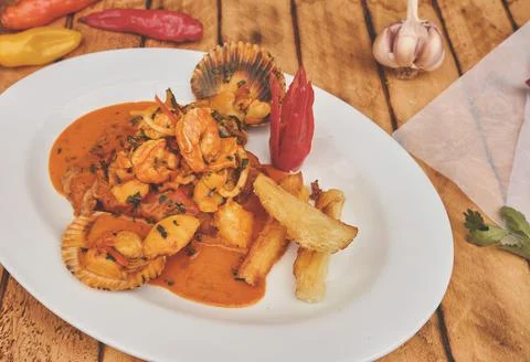 Peruvian culinary fried fish A lo Macho style with seafood sauce Stock Photos