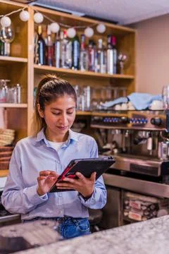 Peruvian entrepreneur doing inventory with touchscreen. Young Latinx Stock Photos