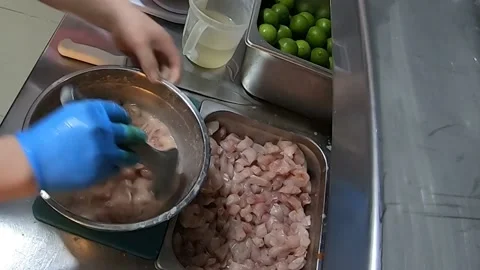Peruvian food CEVICHE, hands preparing in a saucepan: fish, lemon, onion, salt. Video stock 171408703