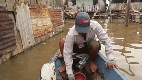 Peruvian man bailing water out of a boat. out of focus Video stock 233288477