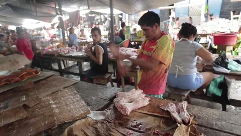Peruvian man cuts meat on the counter with a sharp knife. Iquitos, a traditional Stock-Footage 135746003