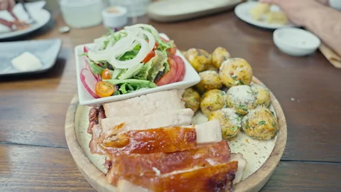 Peruvian roasted pork with crispy skin served with native potatoes 動画素材 339078801