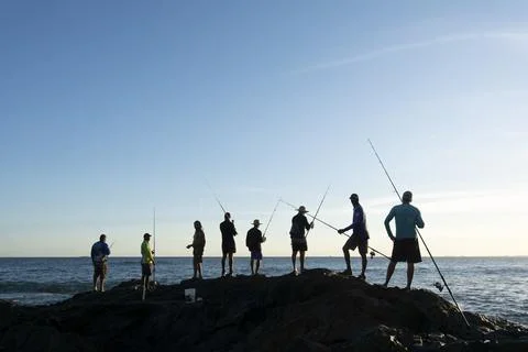 Pescadores com suas varas de pesca sobre as rochas em busca de peixes. Stock Photos