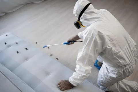Pest control exterminator in white protective suit, mask and gas respirator with Stock Photos