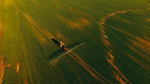Pesticide and fertilizer spraying on the field aerial view with tractor Stock Footage 126531541
