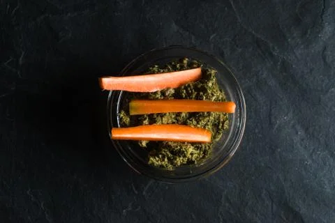 Pesto of carrot tops and carrots on a gray background Stock Photos