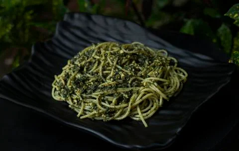 Pesto pasta on a black plate	 Stock Photos