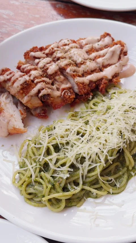 Pesto Pasta with Fried Chicken on White Plate Handheld Slow Pan Stock Footage 340494591