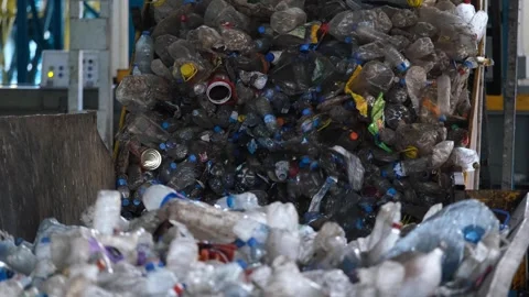 Pet bottle garbage advancing in the press machine to be recycled Stock Footage 294018676