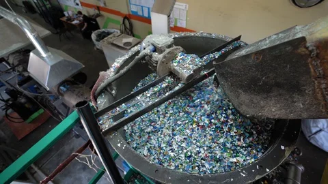 PET flakes through the conveyor fall into the melting machine. Video stock 128998589