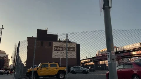 Peter Luger Steak House gritty parking lot fence elevated subway train Brooklyn 스톡 동영상 151234395
