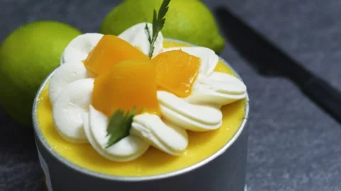 Petite mango mousse cake Tin Can adorned with cream rosettes, fresh mango cubes, Stock Footage 313293744