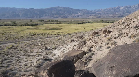 Petroglyphs on rocks in the Eastern Sierra with mountains and blue sky Stock Footage 55882720