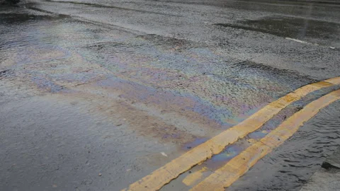 Petrol on a road forming rainbow-like pattern in a puddle. Stock Footage 116807507