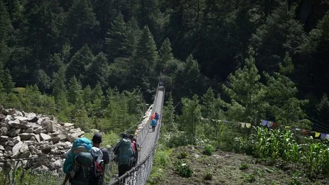 PHAKDING, NEPAL 11 SEPTEMBER 2017 : A Group of Trekkers Passing a Hanging Bri Stock Footage 84923724