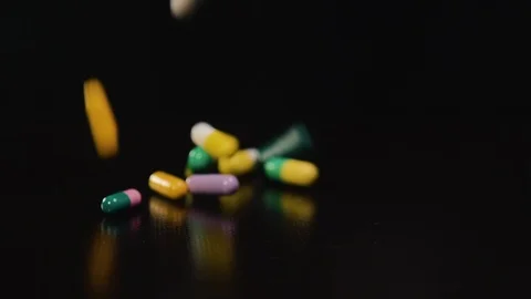 Pharmaceutical drug, a bunch of multi-colored round capsules of tablets with Stock Footage 102027928