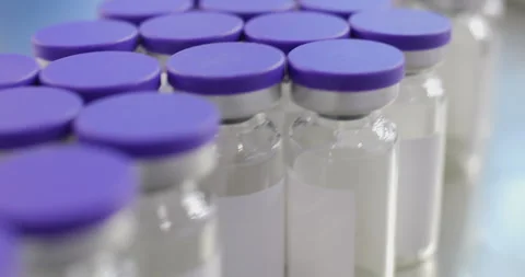 Pharmaceutical factory machine arranging vials filled with liquid Stock Footage 293095209