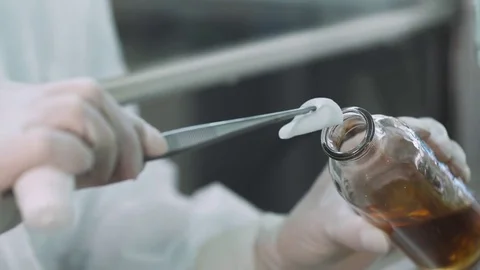 Pharmaceutical laboratory, medical laboratory worker removes the cotton disc. Stock Footage