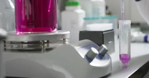 Pharmaceutical laboratory. Purple sample mixing in a magnetic stirrer is poured Stock Footage 274222748