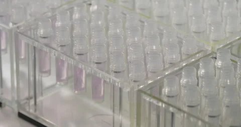 Pharmaceutical manufacturing line. Robotic arm pours liquid into test tubes Stock Footage 272499536