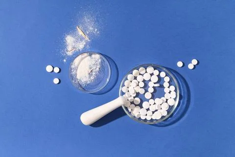 Pharmaceutical research and development with white pills, powder, and mortar  Stock Photos