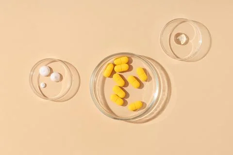 Pharmaceutical research and development with yellow pills, white cream, and c Stock Photos
