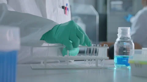 A pharmaceutical research laboratory operator pours liquid into vials 動画素材 274351177