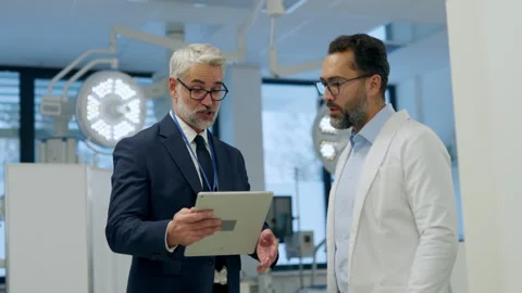 Pharmaceutical sales representative presenting new medication to doctor in Stock Footage 264110886