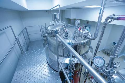 Pharmaceutical worker using large machine. person checking medicine liquid makin Foto stock