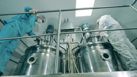 Pharmaceutics workers are managing fermentation reactors Stock Footage 138799903