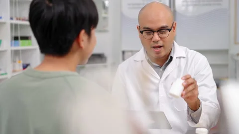 Pharmacist analyzing about customer symptoms for buying pill. Vídeos de archivo 248040190