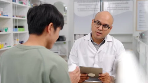 Pharmacist analyzing about customer symptoms for buying pill. Stock Footage 248770302