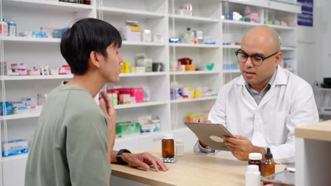 Pharmacist analyzing about customer symptoms for buying pill. Stock Footage 254710622
