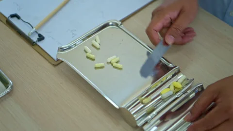 The pharmacist is arranging medications on sorting trays and counting Video stock 339057270