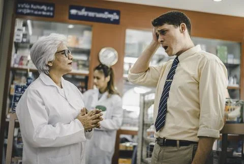 Pharmacist is asking about a patient's condition in order to prescribe medi.. Stock Photos