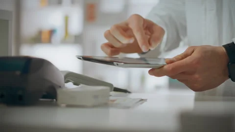 Pharmacist assistant uses skills working on an electronic tablet in the phar Vídeos de archivo 277163760